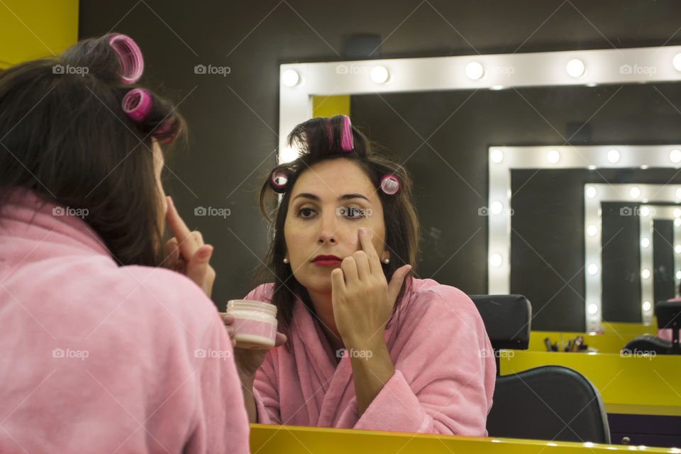 Girl doing skincare facing the mirror
