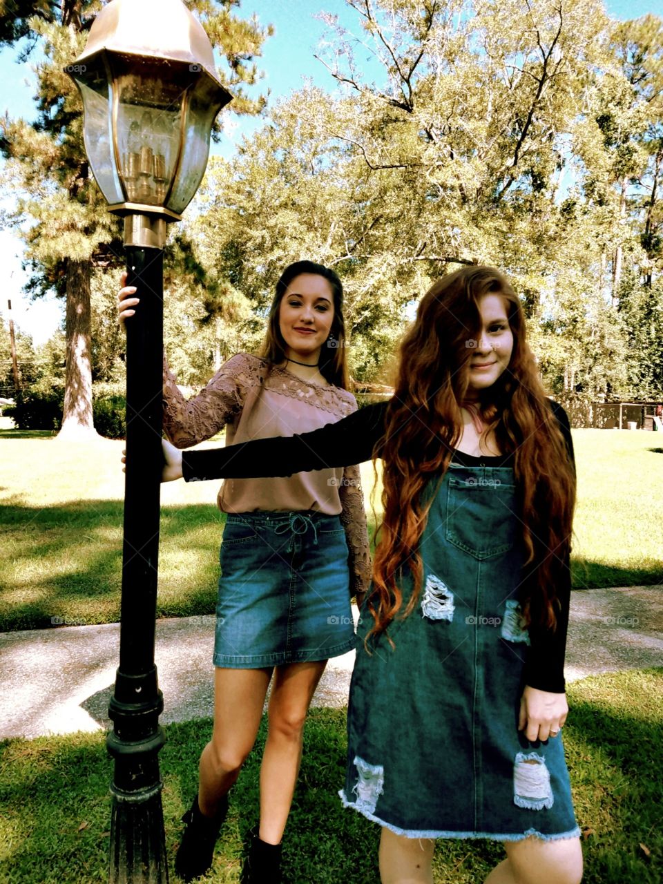 Two beautiful girls by a lamp post in the fall