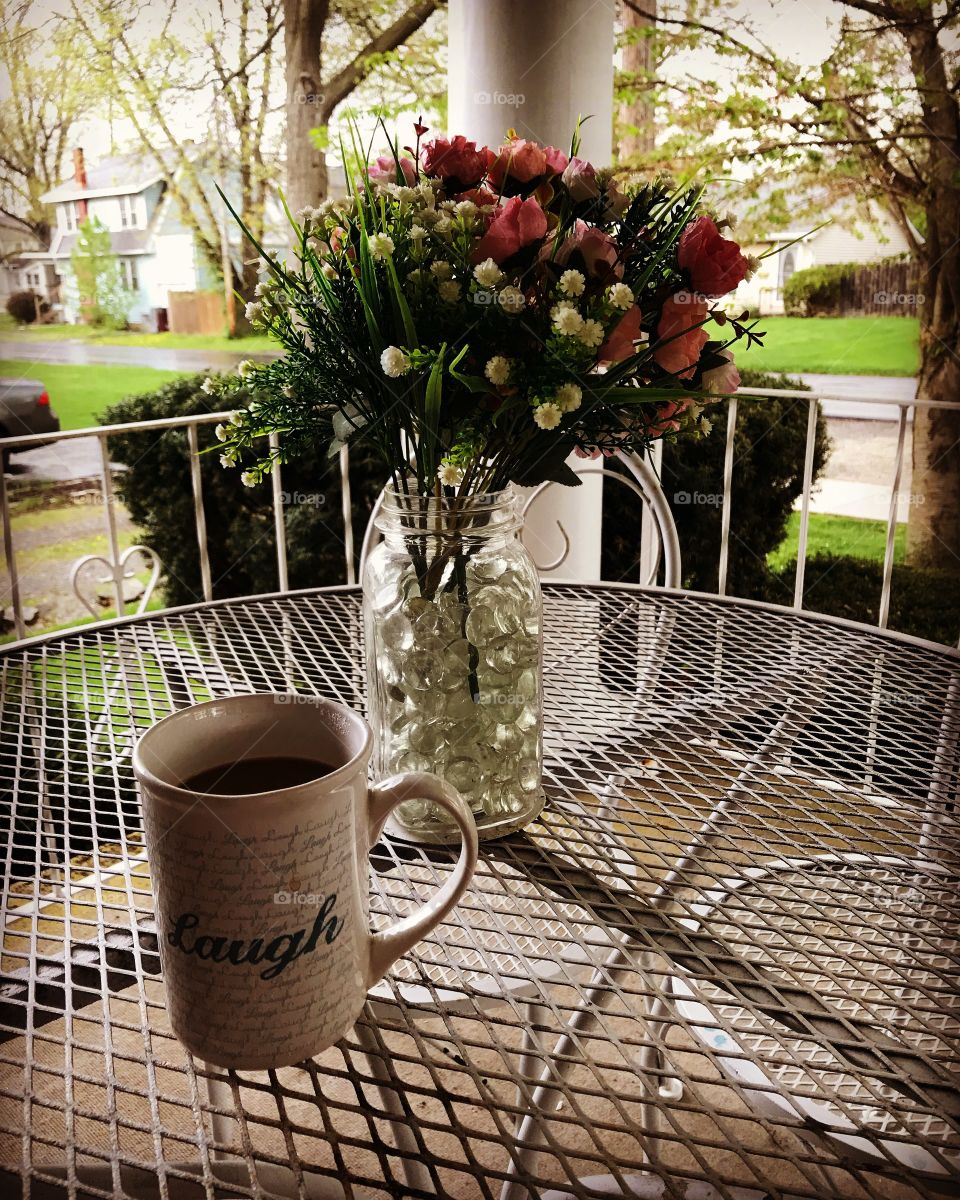 Coffee on the front porch, and flowers on table