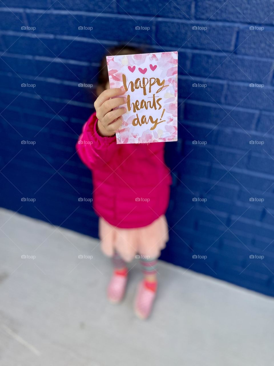 Toddler girl holds Valentine’s Day card, little girl receives mail, receiving mail for Valentine’s Day present, getting mail from Grandma 