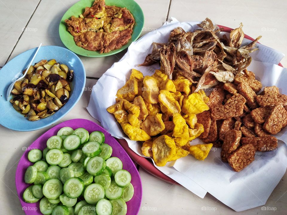 Some side dishes for Indonesian food that are fried include tempeh, tofu, salted fish, eggs and jengkol. Ready to eat together with rice, chili sauce and fresh cucumber slices