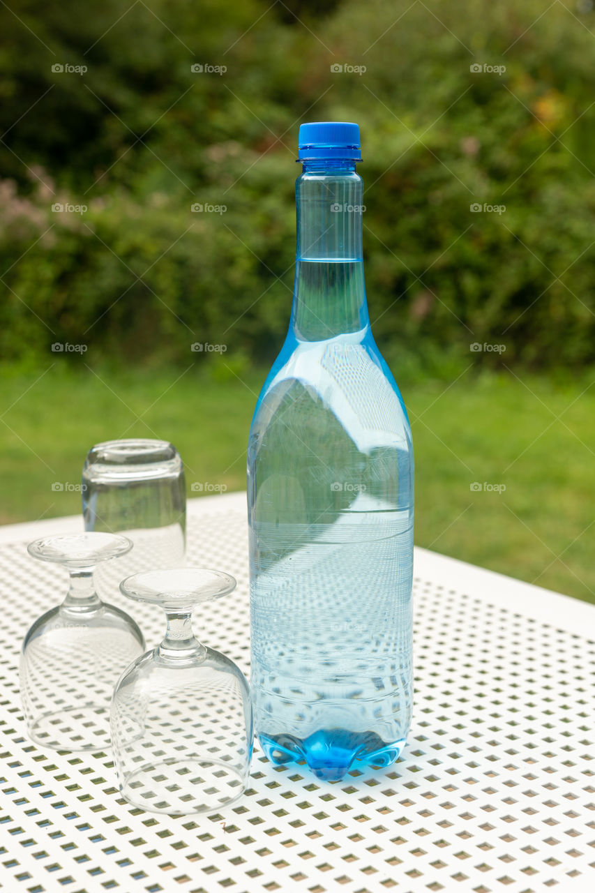 blue bottle of water and two glasses