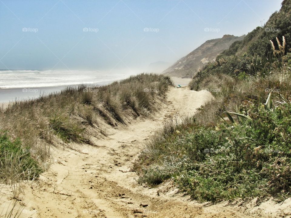 beach track in the sand dunes waves in distance