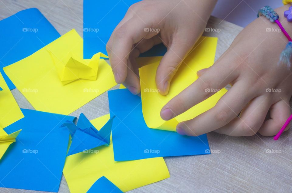 a child makes a crane out of paper