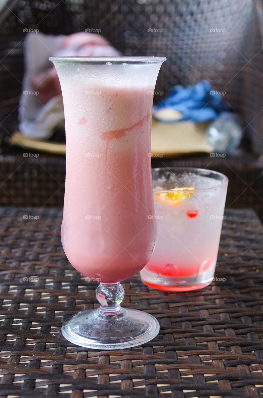 Refreshing cold coconut cocktails on the wooden table.  Ingredients coconut milk and coconut water