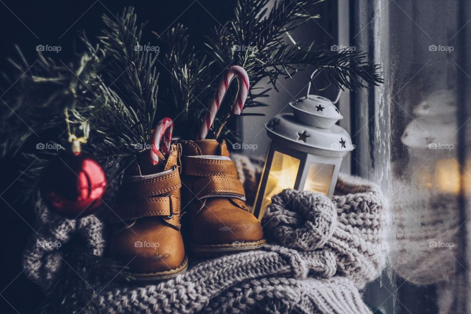 still life with fir branches, children's boots and a lantern