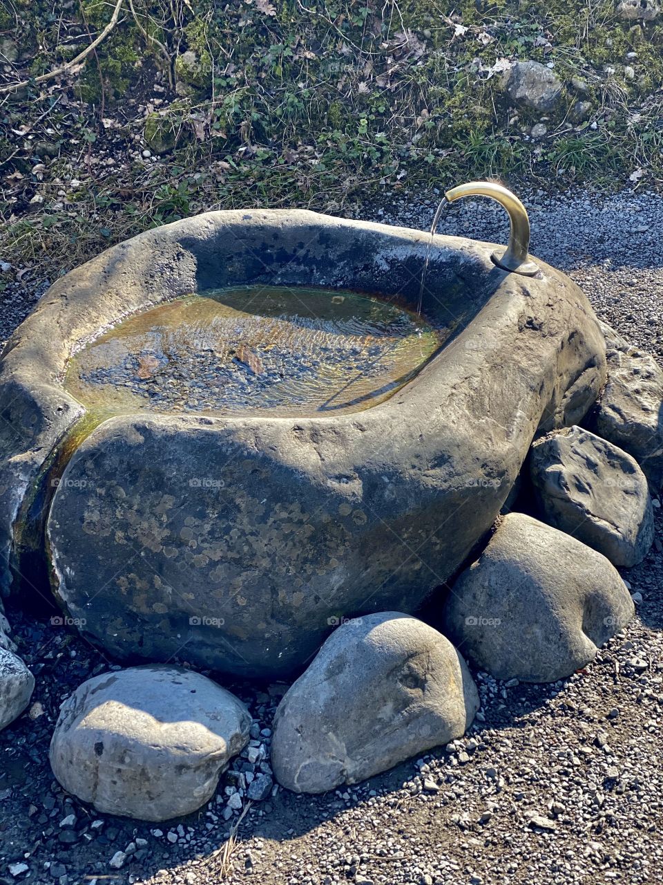 stone round fountain, water flows from the fountain, large round stones, nature