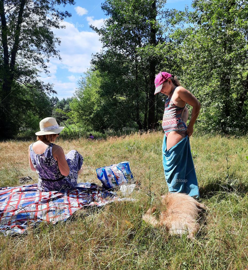 family with a dog on river bank