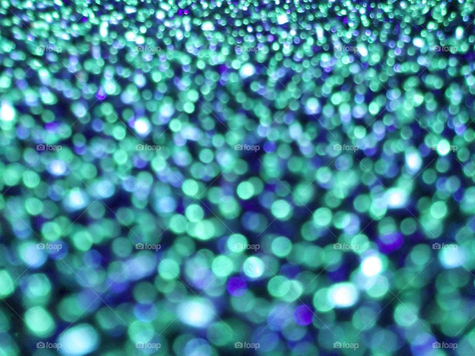 Colorful twinkling blurred background with green and blue lights