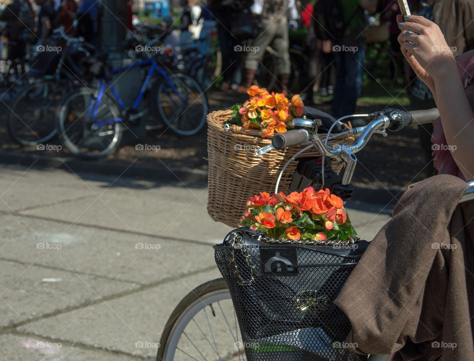Flower baskets with orange begonia on bicycles