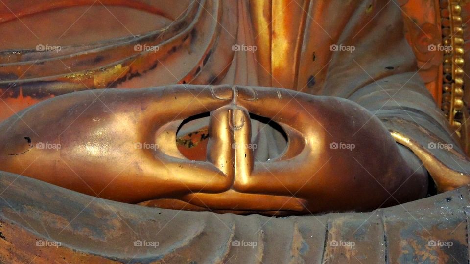 Peaceful yellow hands. Statue in Hawaii with up close hands in a temple