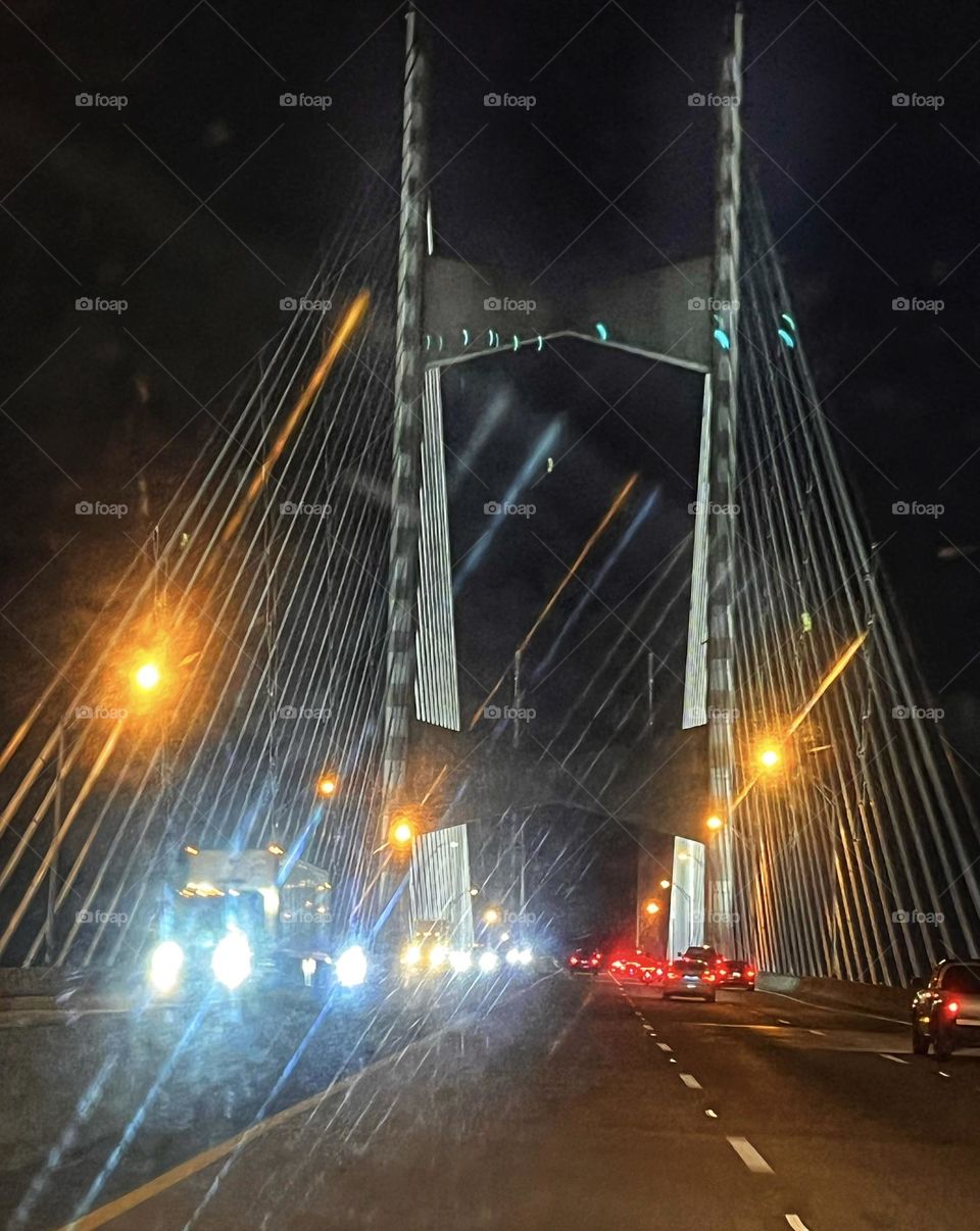 Suspension bridge at night with vehicle headlights and taillights 