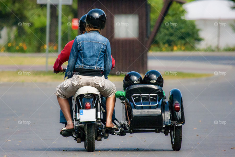 Couple and two kids riding sidecar motorcycle in the summertime