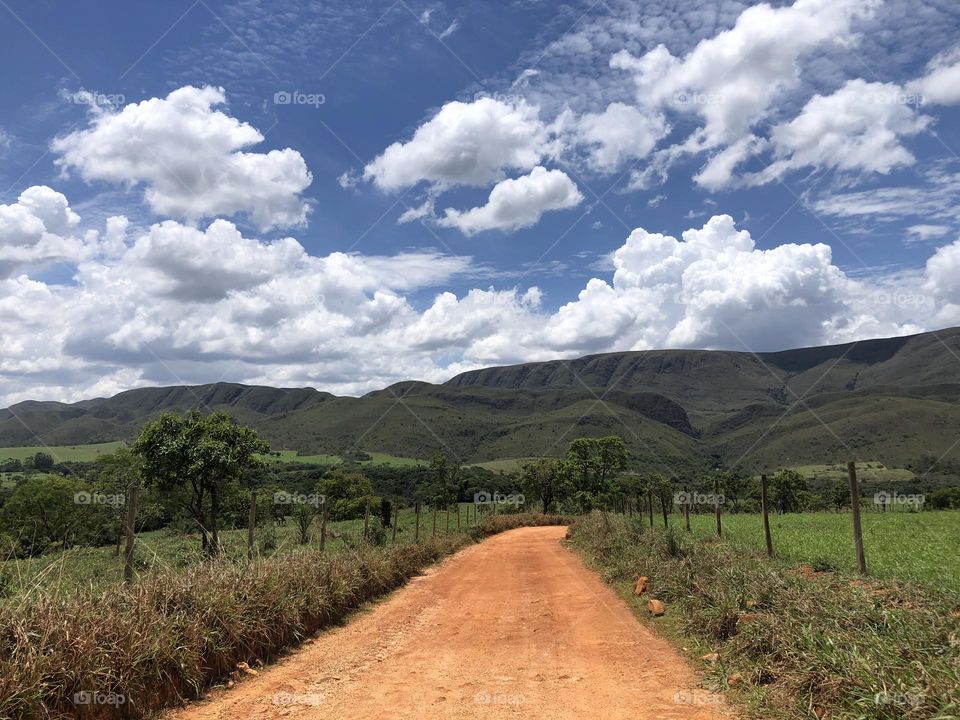 Green Mountain View surrounded by nature in a sunny day and a dirty road