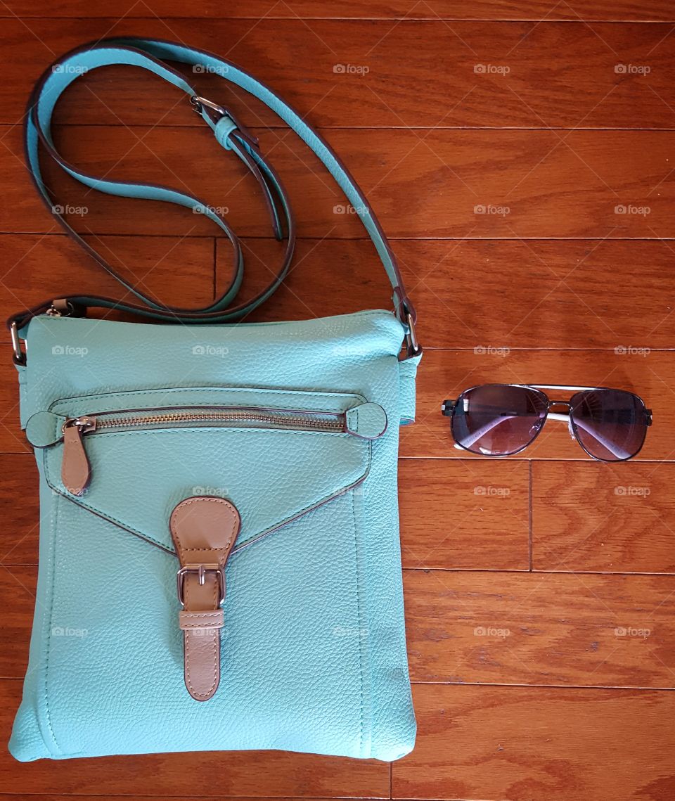 Hand bag and sunglasses on table