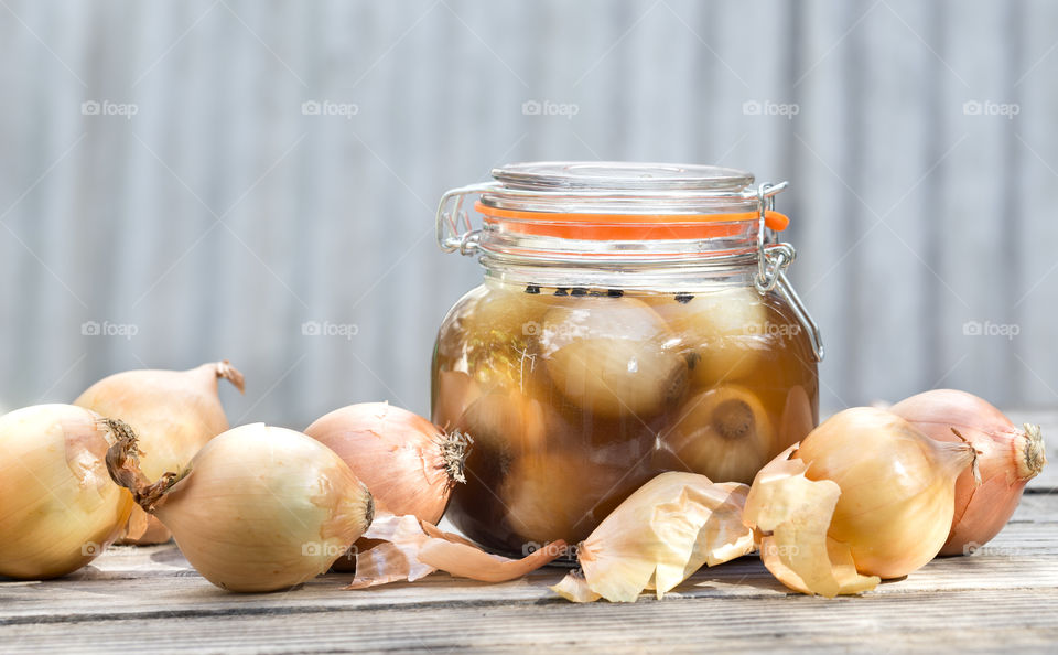 Jar of pickled onions with raw onions