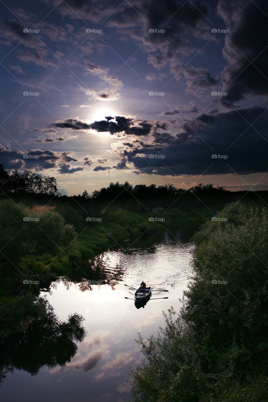 River boatman. Sunset over the river