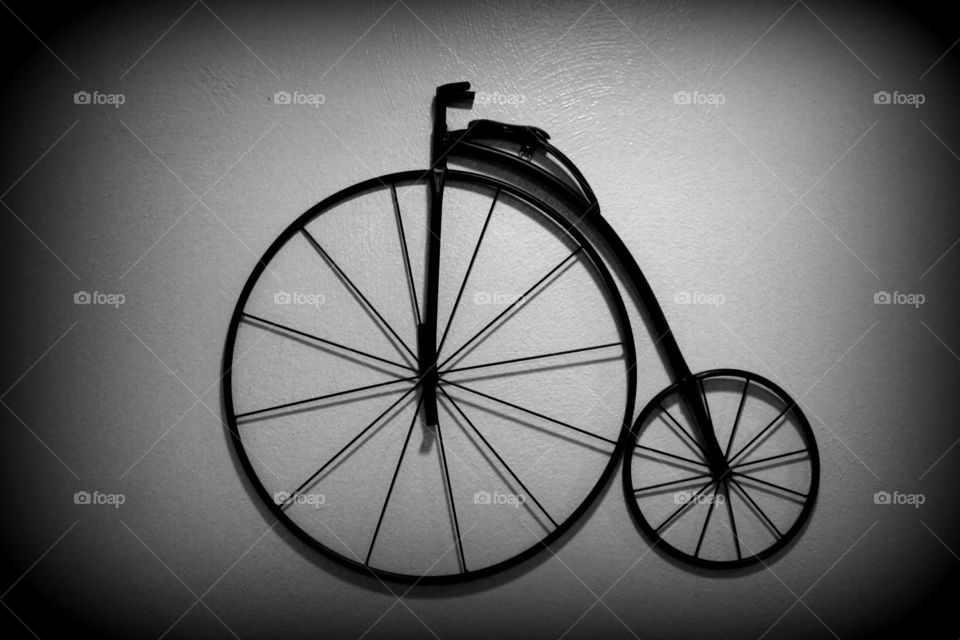 This is picture art of a bicycle on the wall done in black and white to add character to the picture.