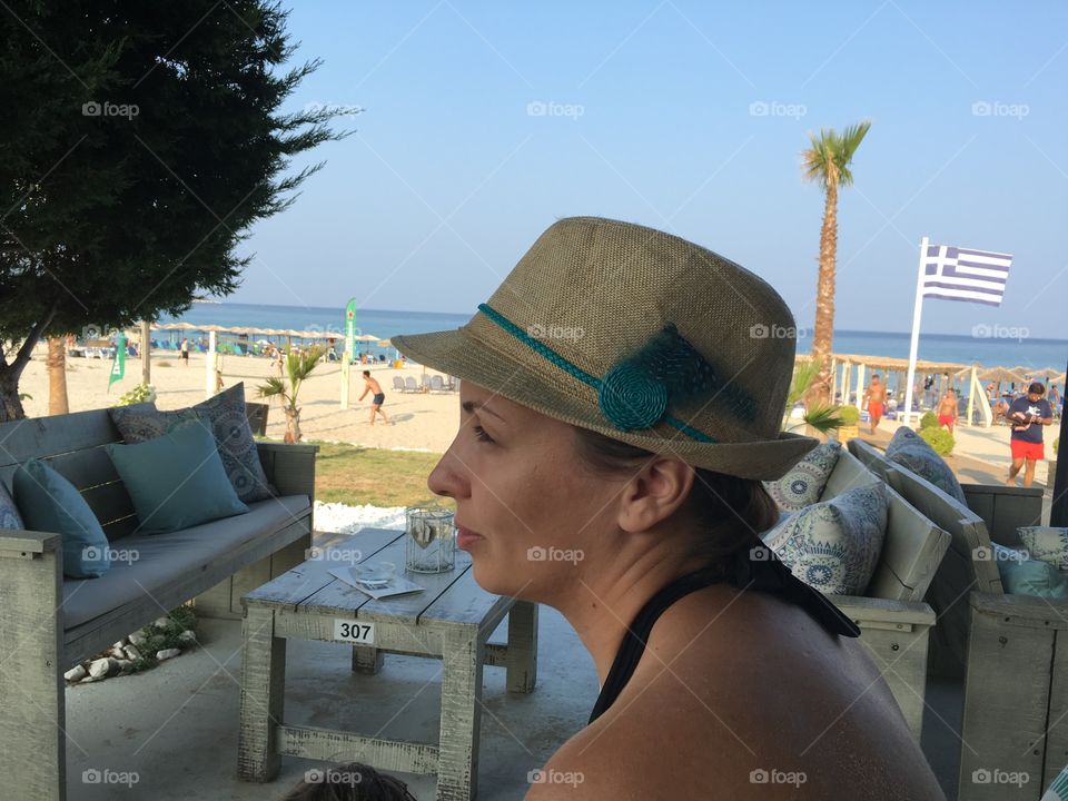 Woman with hat at cafe on the beach