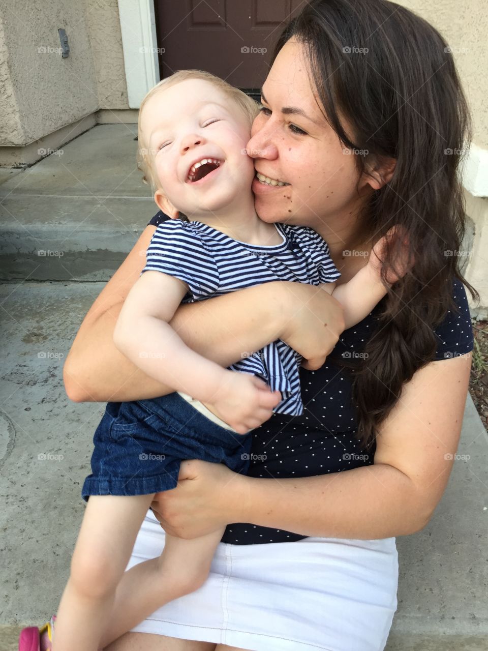 Mother and daughter laughing outside 