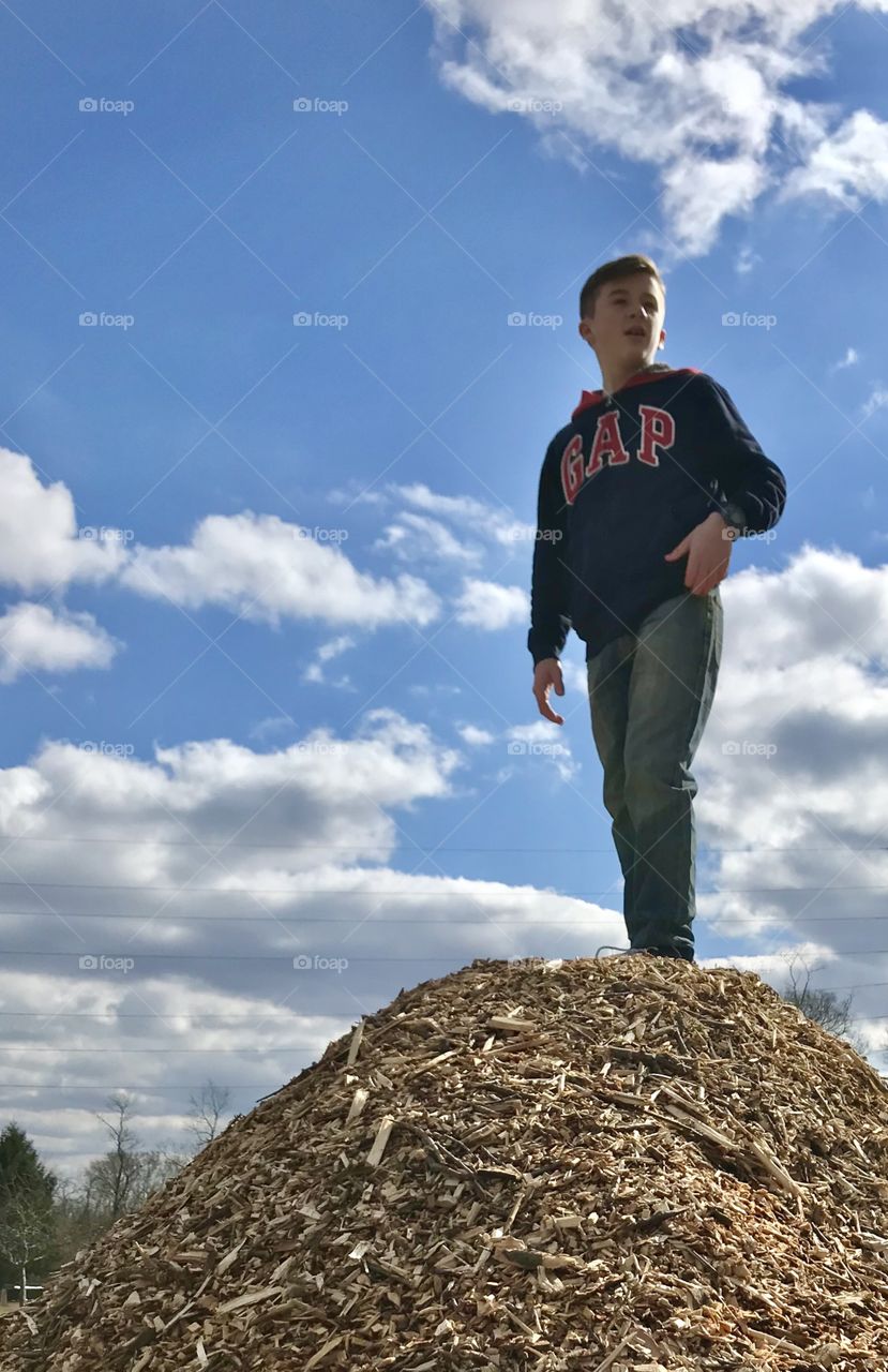 Boy standing on top of mulch 