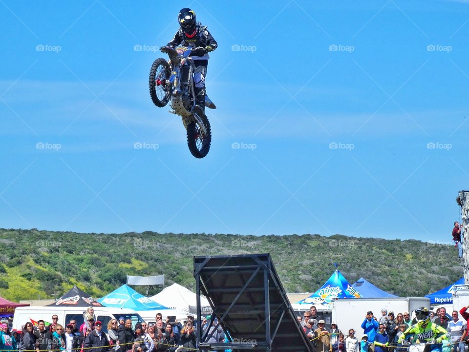 Motorcycle Stunt. Stunt Performer Jumping A Motorcycle Off A Ramp
