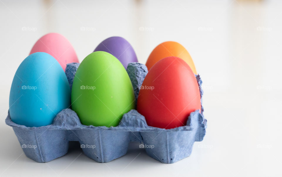 Colorful Easter eggs in a cardboard isolated on white background.