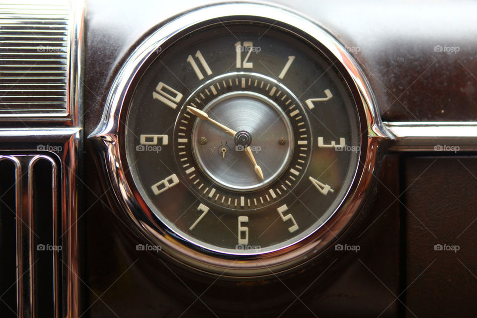Old style art deco clock on vintage Cadillac dashboard