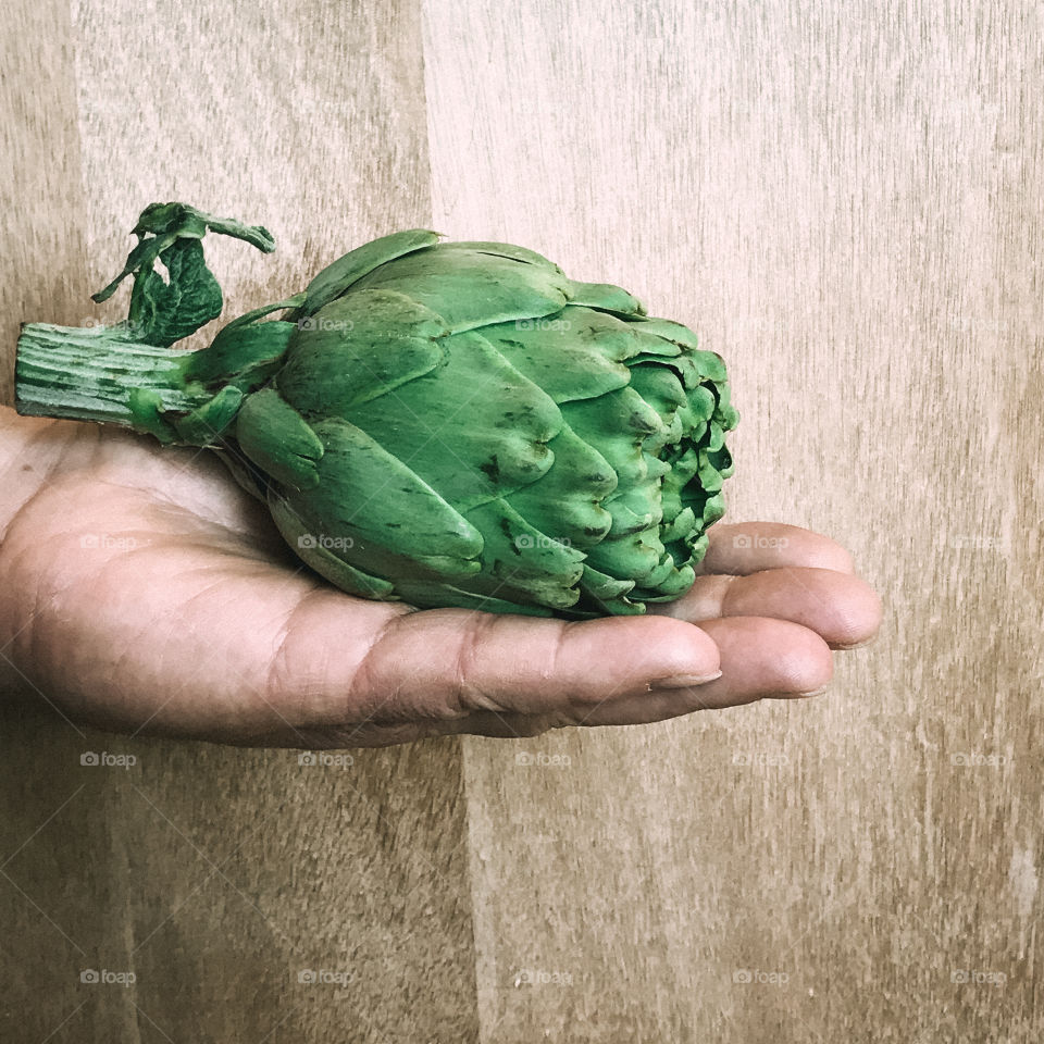 Hand holding artichokes 