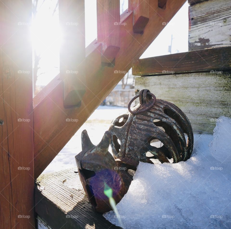 A metal snail on the back steps, waiting for the sun to melt the snow around it. 