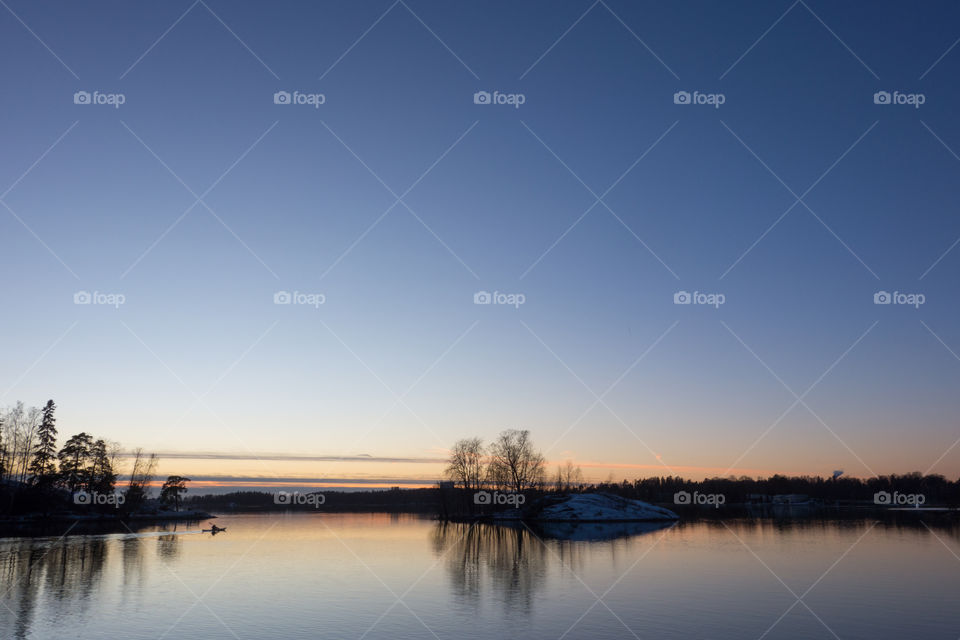 Unidentified man baddling in the Baltic Sea in cold December evening after sunset in Helsinki, Finland.