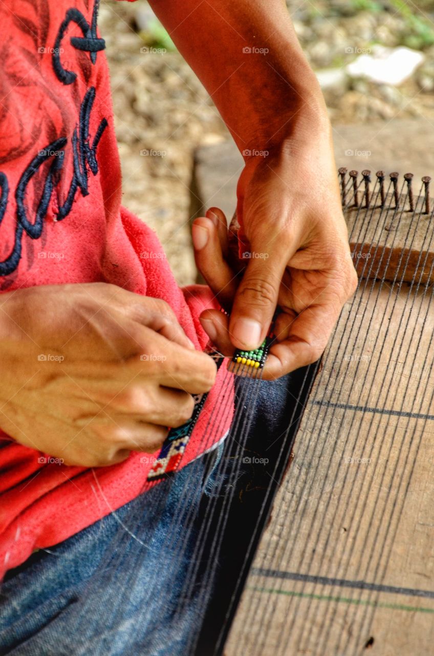 Indigena de Panamá tejiendo pulsos.
