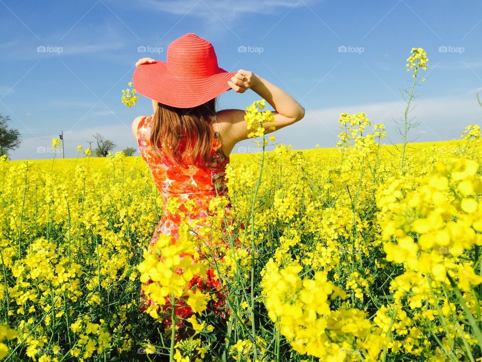 Rear view of a woman in rapeseed field