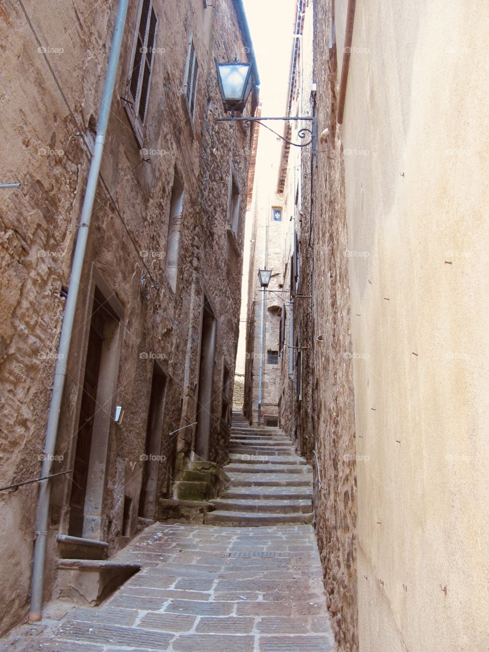 Narrow alleyway between ancient buildings brown stone architecture 