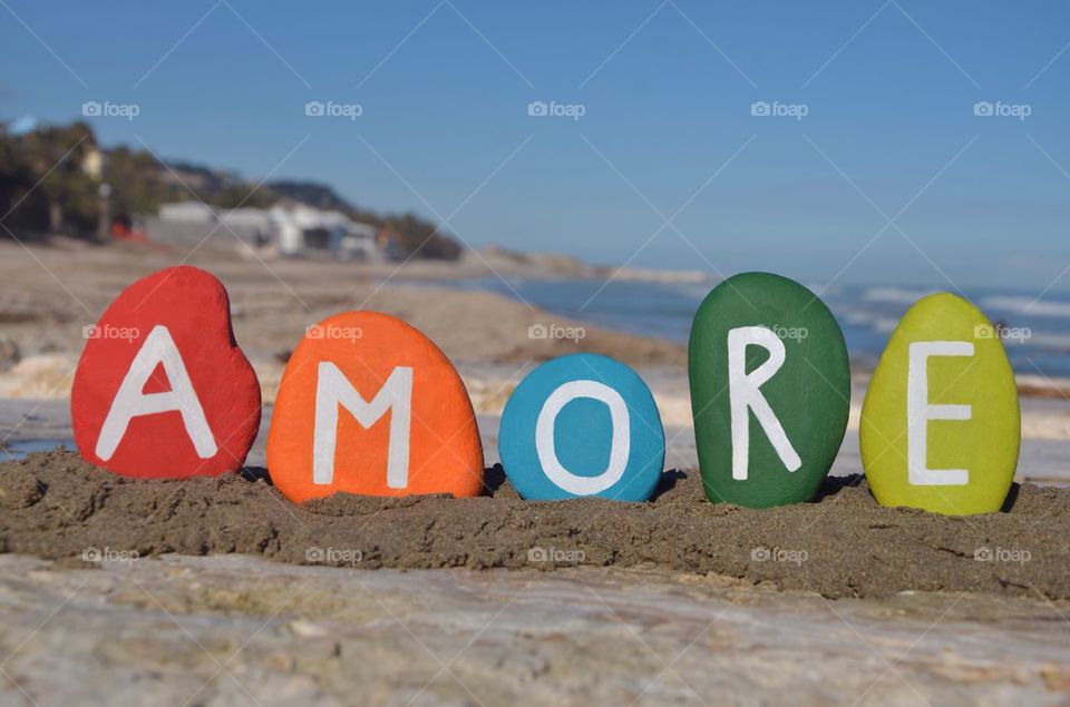 Amore, love in italian language on colourful stones