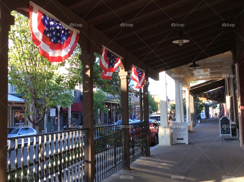 Banner flags hanging along street sidewalk 