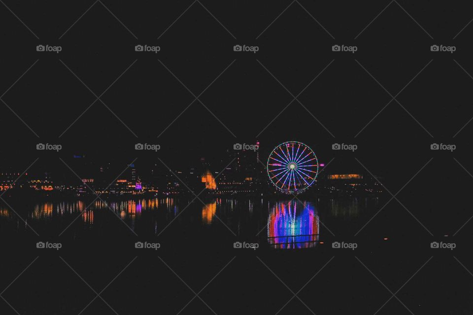 A bright carnival fully reflected onto a lake