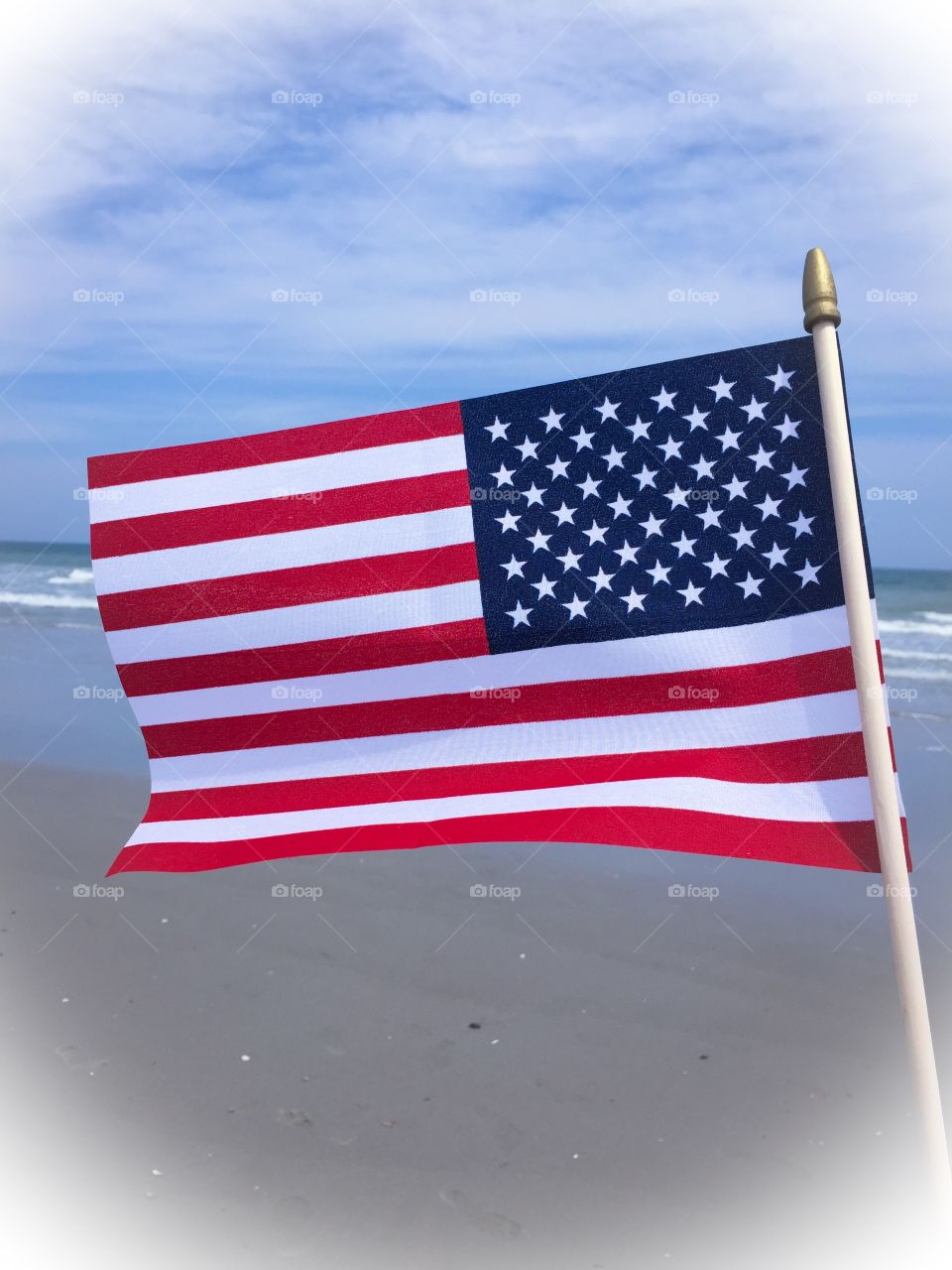 American flag. An American flag flies by the seashore.