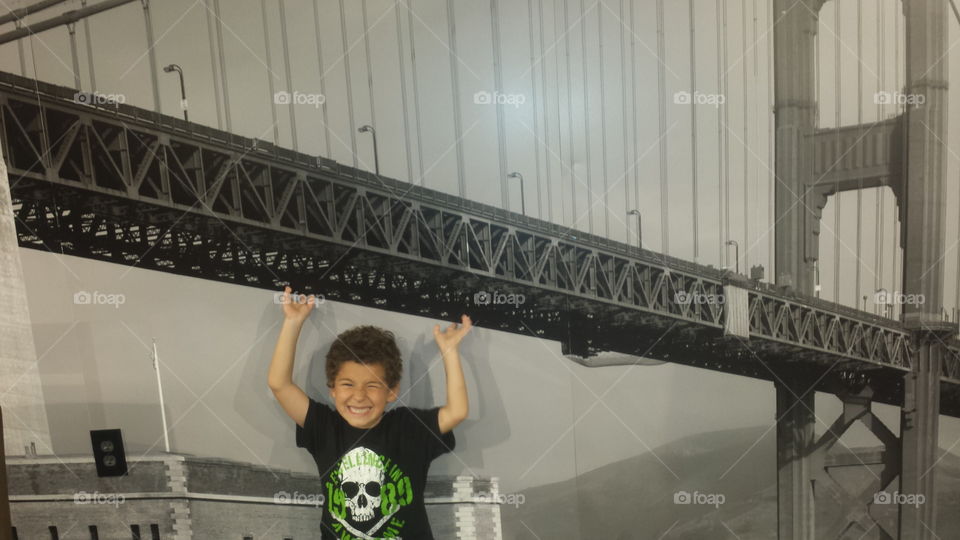 Boy posing under bridge