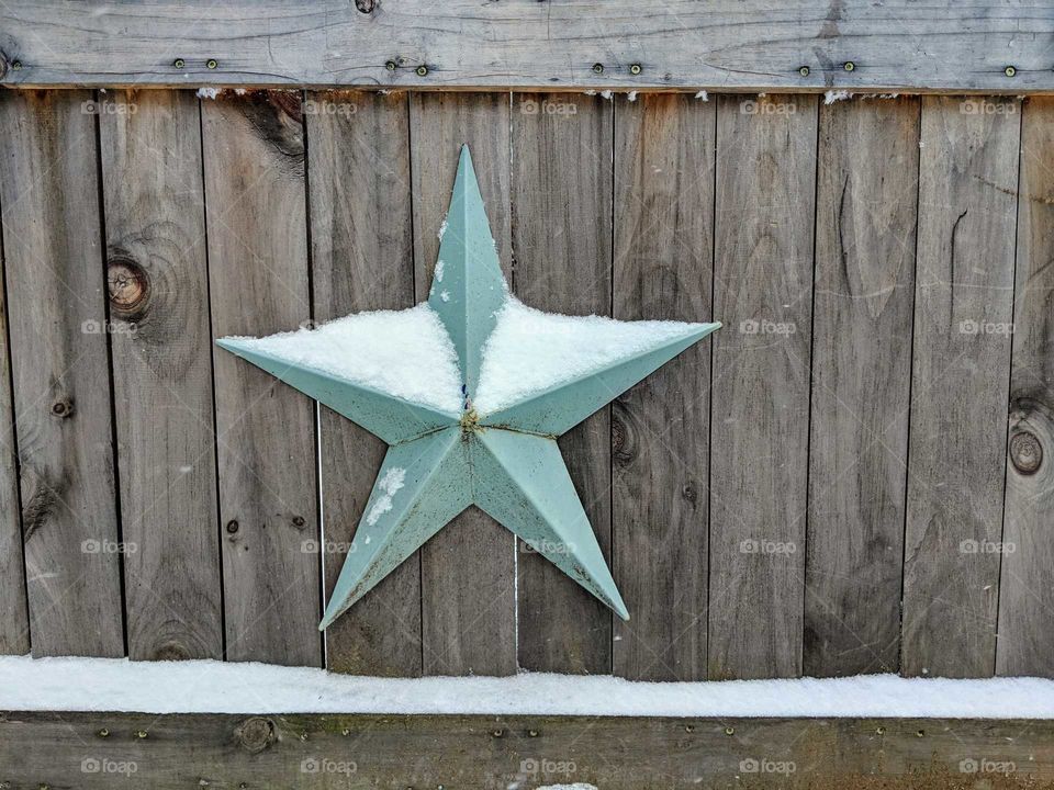 snowy barn star on a wooden gate