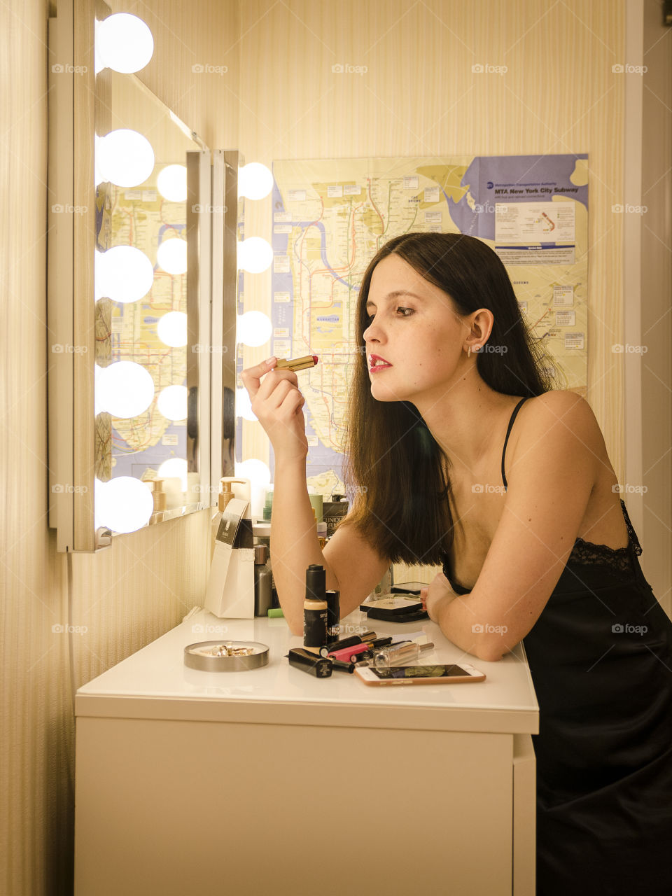 Woman putting make up near home mirror at night