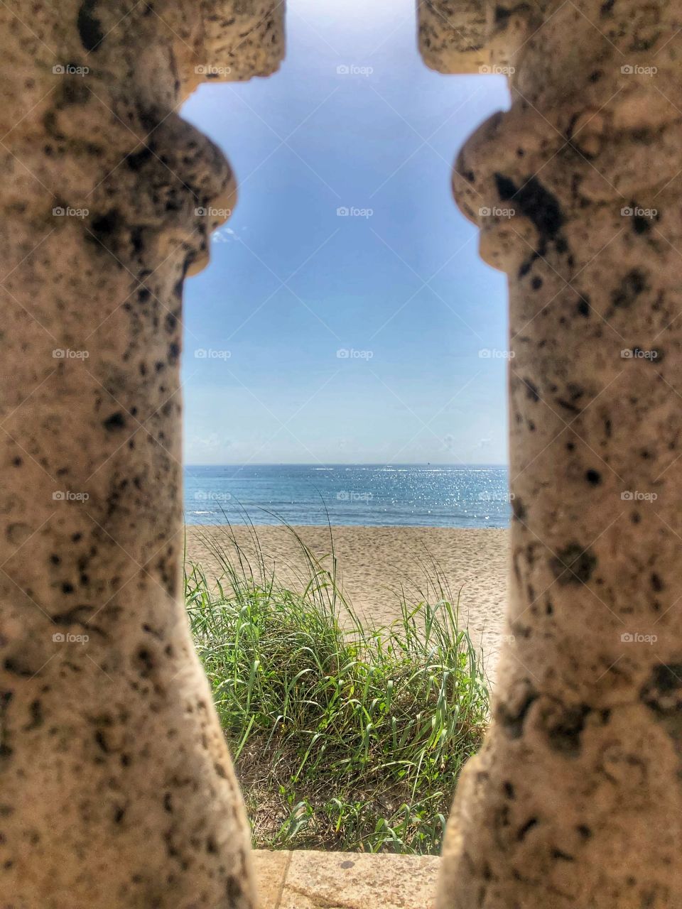 Peak at the beach between 2 pillars 