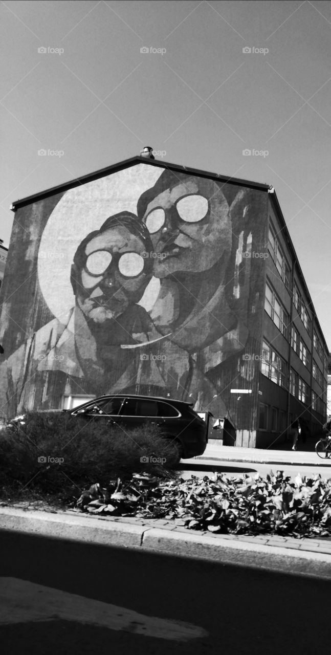 A huge painting representing two figures on the wall of a building in Jyvaskyla city