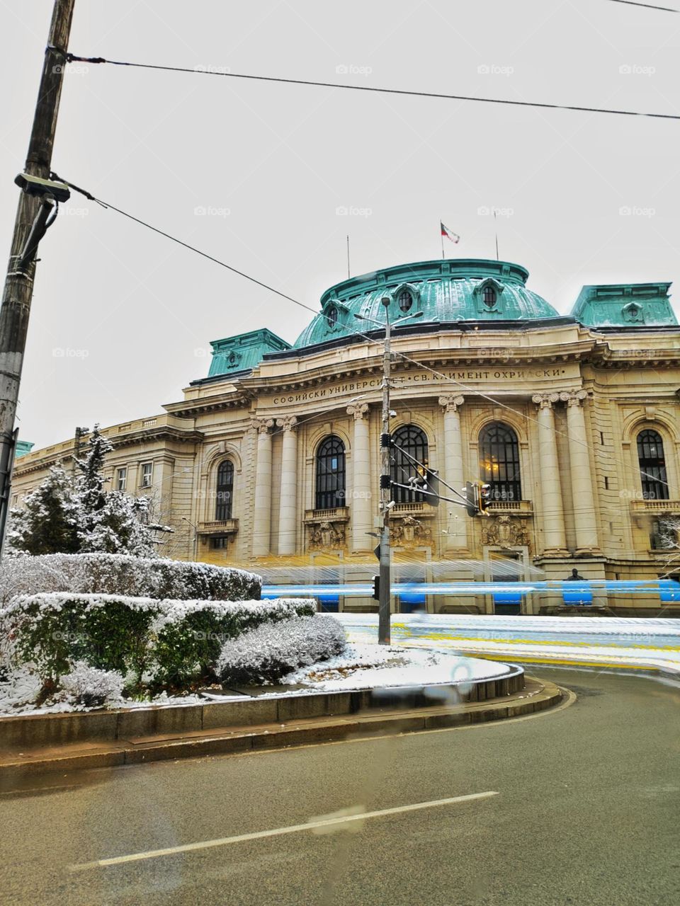 A beautiful scenery in the centre of the capital city of Bulgaria, with its most famous university and neon trails from the passing vehicles in the winter