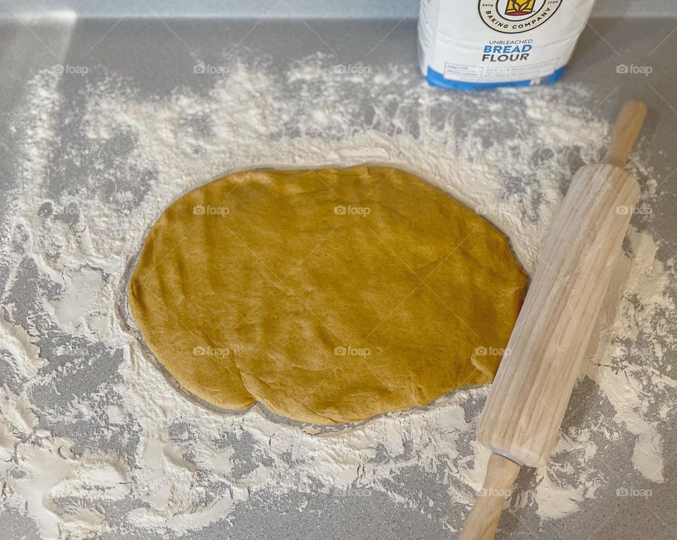 Rolling out the dough for making pumpkin cinnamon rolls, baking at home with toddlers, making a mess baking at home, homemade pumpkin cinnamon rolls