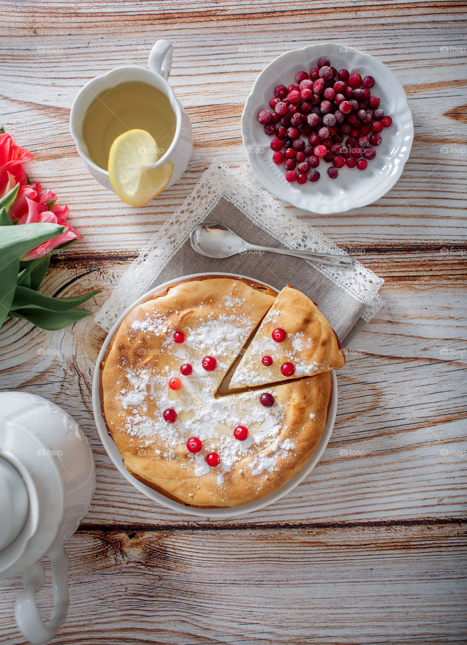 Cheesecake with cranberries and sugar on wooden background