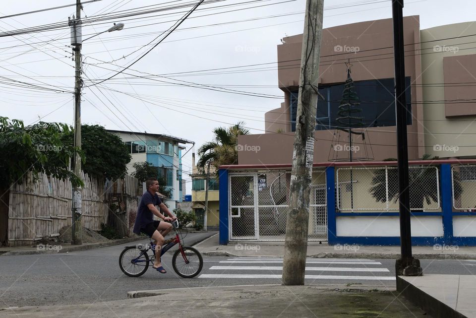 Person with bicycle riding on the track on an avenue in the city of machala in ecuador.