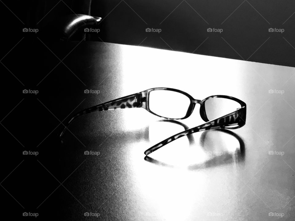 Glasses on a table with a window in the background in black and white 