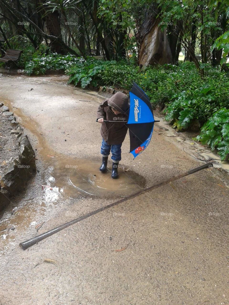 Criança a saltar numa poça de água