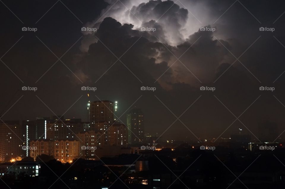 Storm clouds and illuminated lights of buildings